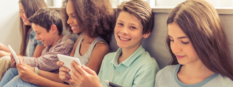 Children using smart devices on the couch