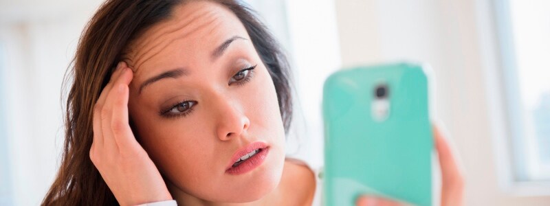 Stressed woman looking at phone